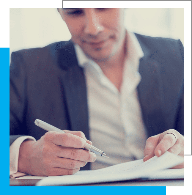 A man in a suit writing on paper.