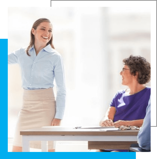 A woman standing at a table with two other people.